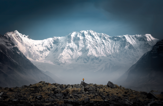 The South Face of Annapurna at sunrise with a Life Happens Outdoors team member enjoying the view alone during the Annapurna Base Camp Trek.
